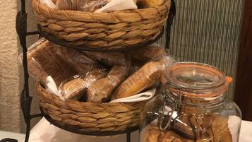 A display of baked goods including muffins and cookies in baskets and a jar.