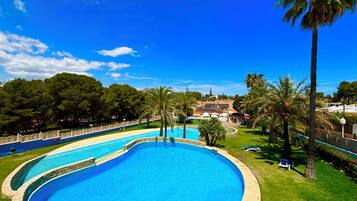 En säsongsöppen utomhuspool och solstolar