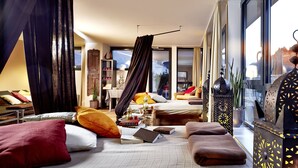 Een moderne hotelkamer met een groot bed, een bureau en uitzicht op de bergen.