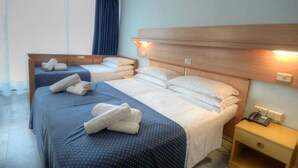 A hotel room with two beds, each with a wooden headboard, a bedside table with a phone, and a window with curtains. - Mimosa (Lignano Sabbiadoro)