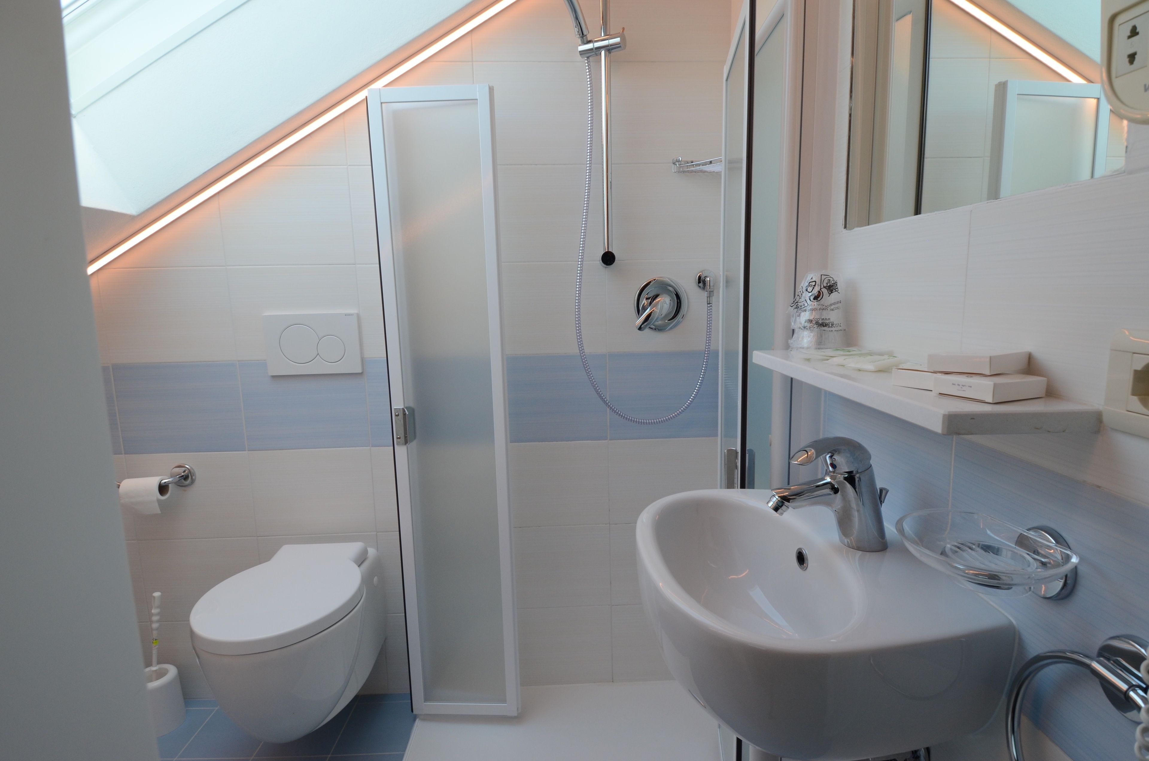 A modern bathroom with a toilet, shower, and sink.