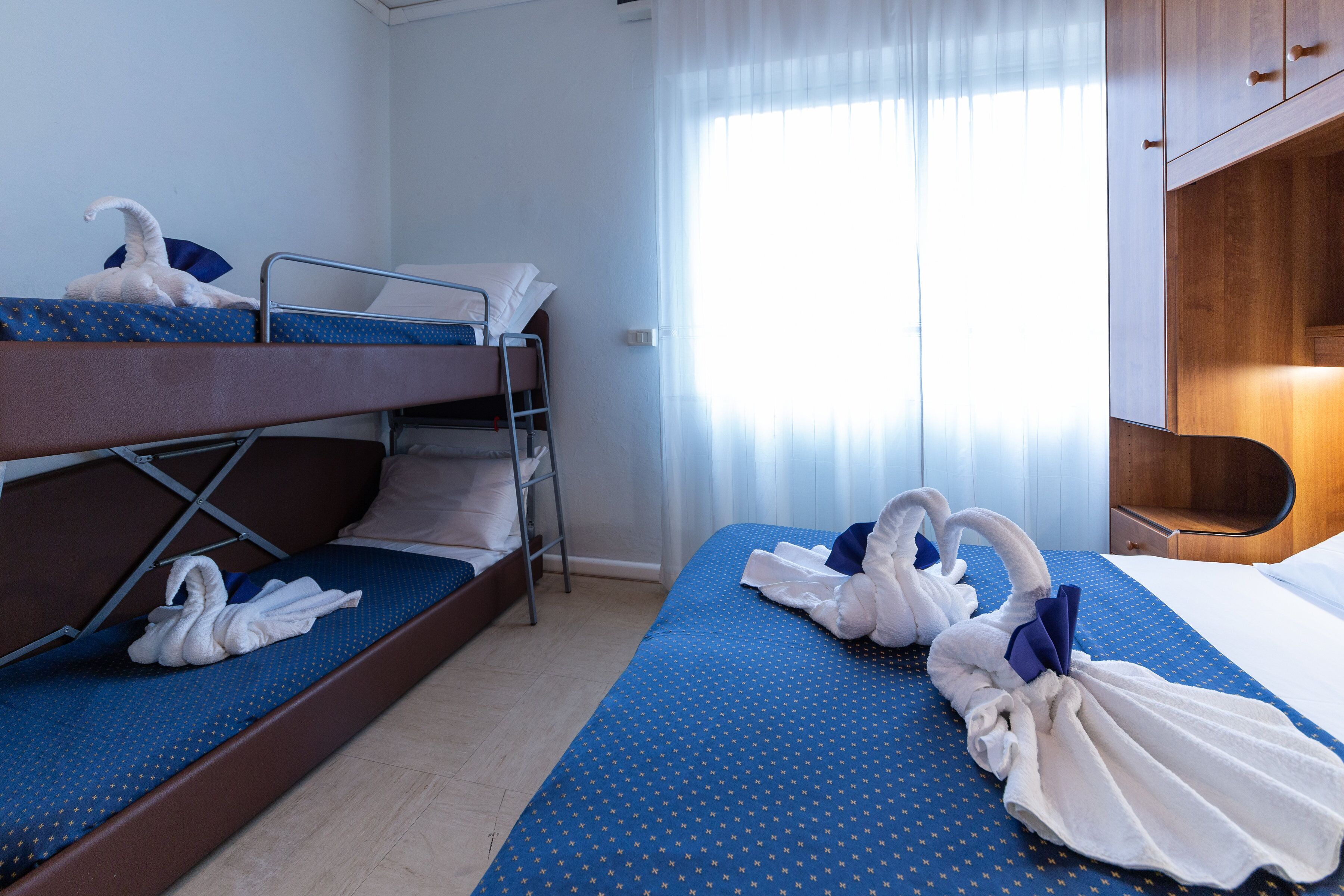 Une chambre d’hôtel avec deux lits superposés, un bureau et une chaise.