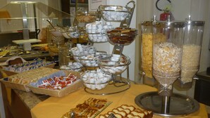 A buffet with various food items and utensils. - Mimosa (Lignano Sabbiadoro)