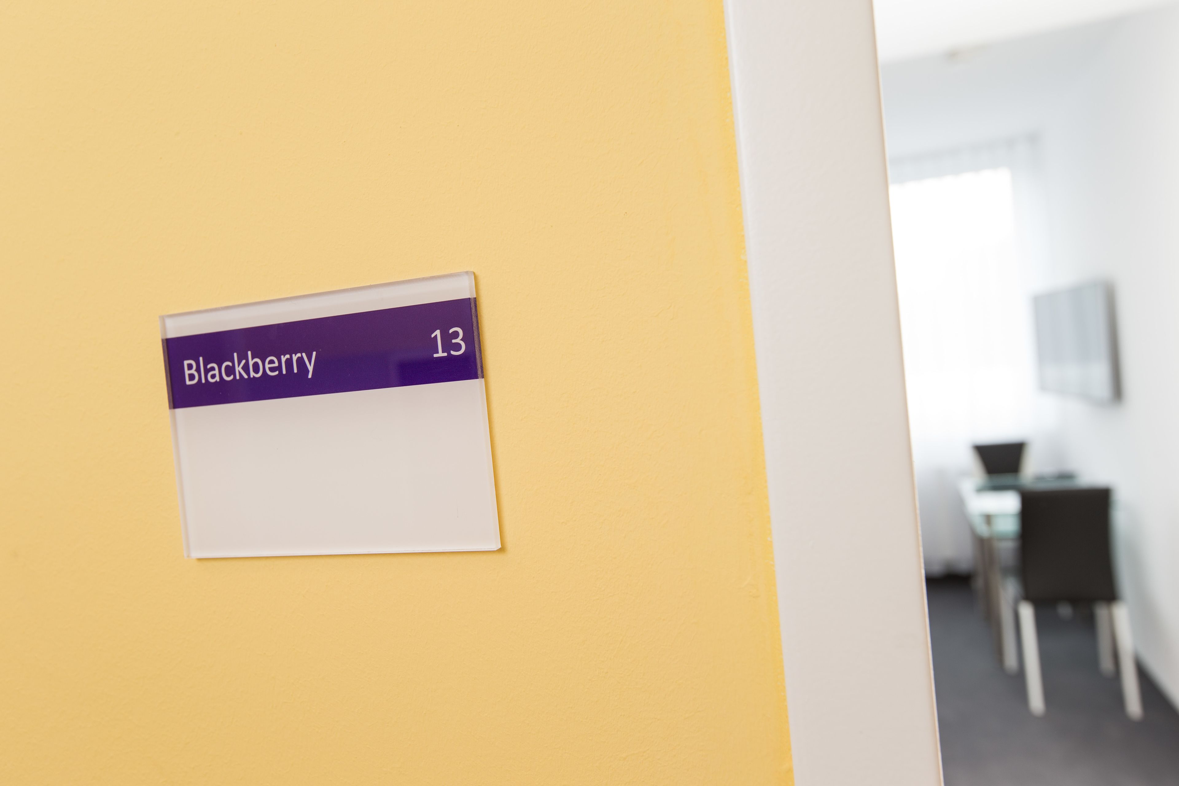 A sign with the word "Blackberry" and the number 13 on a yellow wall.