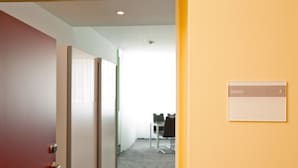A hotel room with a door leading to a hallway. A sign on the wall indicates room number 3. - Design Sleepy Cologne (Cologne)