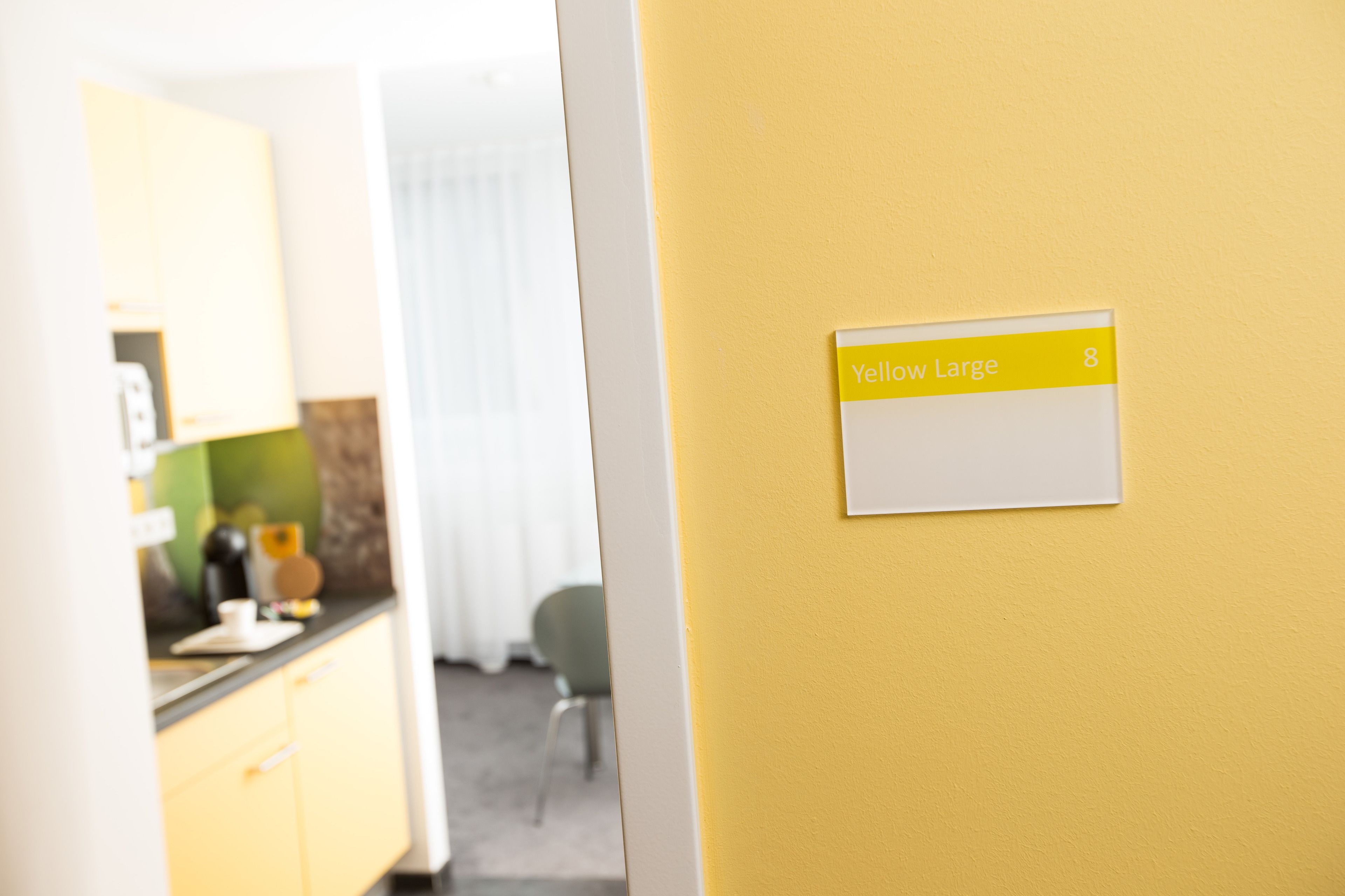 A yellow wall with a sign indicating a room size of 8.