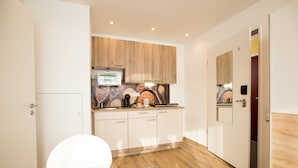 A modern kitchen with wooden cabinets, a built-in oven, and a microwave. - Design Sleepy Cologne (Cologne)