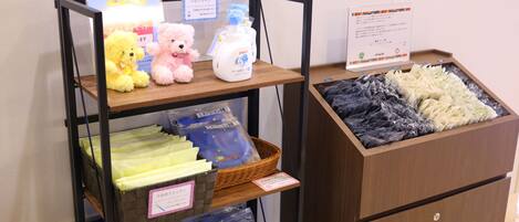 A display with plush toys, cleaning supplies, and folded linens.
