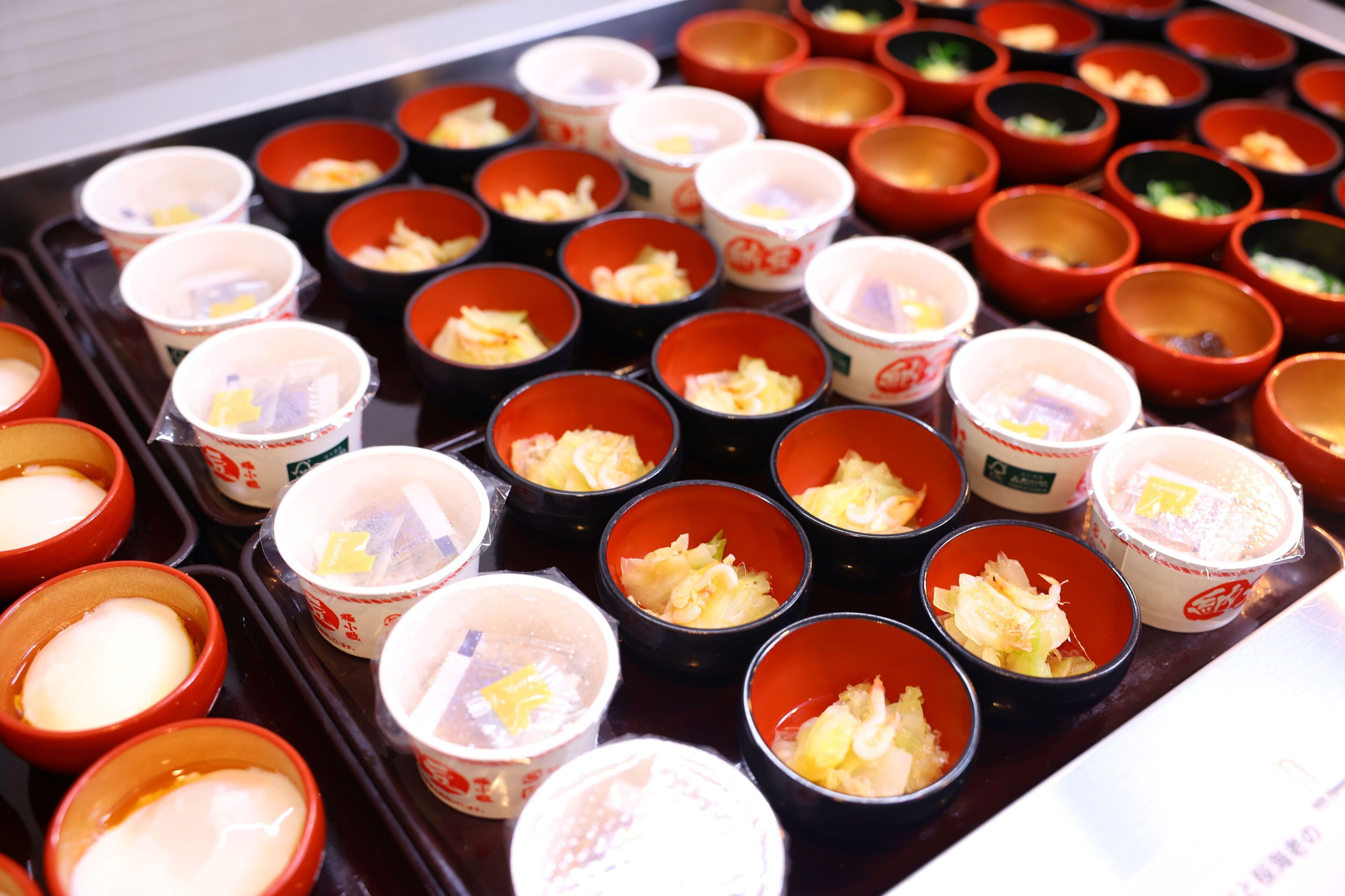 Un plateau contenant de petits bols remplis de différents aliments, probablement pour un repas ou une collation.