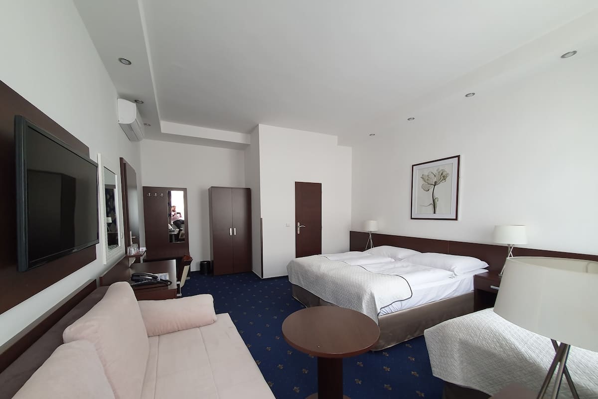 Deluxe Triple Room | Minibar, in-room safe, desk, iron/ironing board