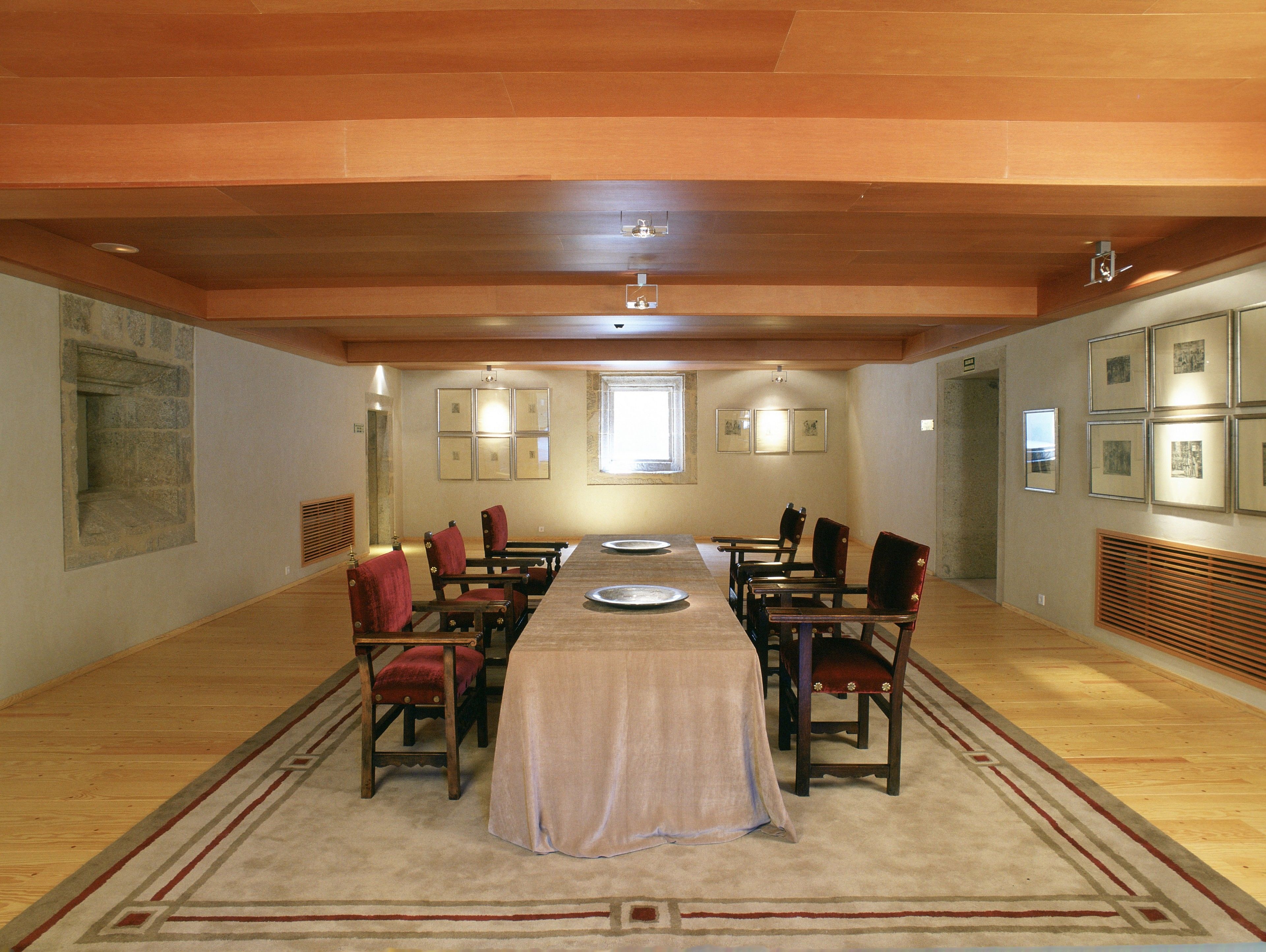 Comedor con una mesa larga, sillas y piso alfombrado.