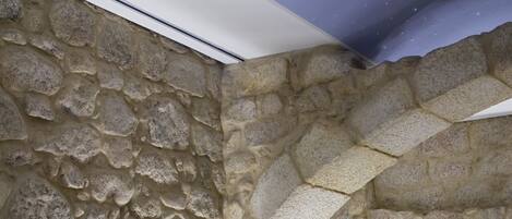 Habitación con paredes de piedra, asientos modernos y techo con estrellas.