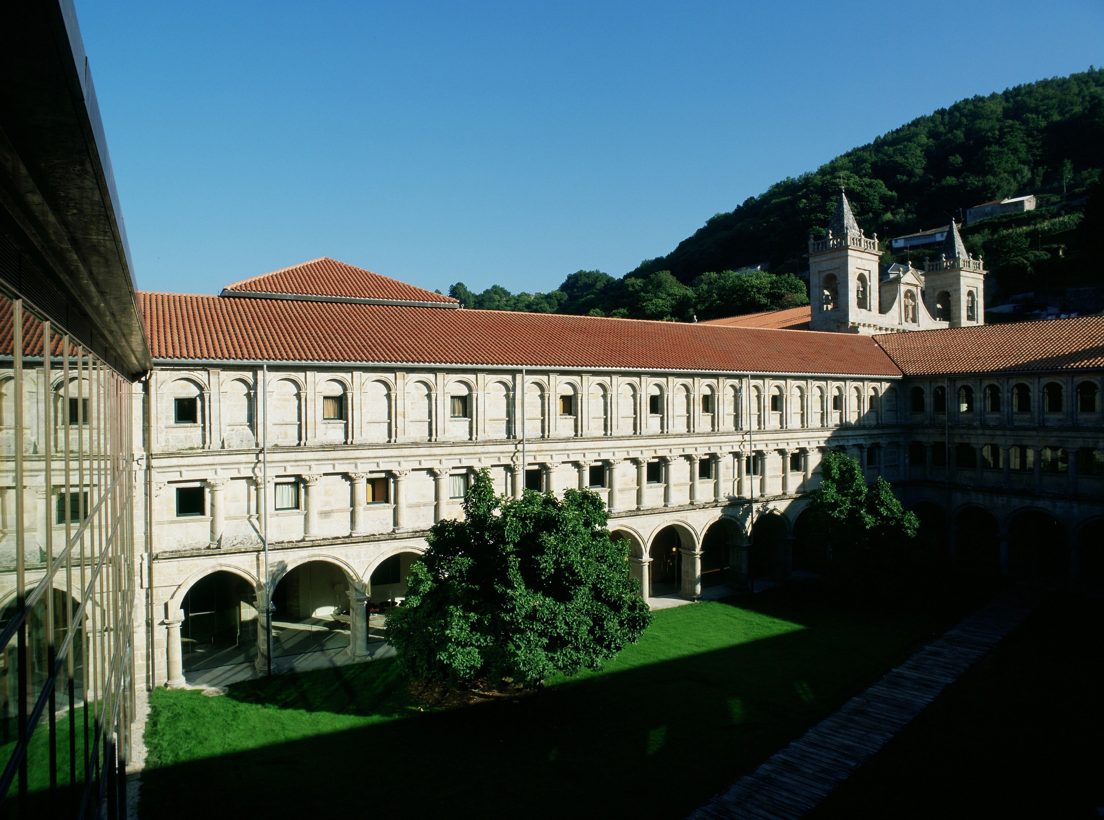 A historical building with a courtyard, arched walkways, and a tower.
