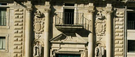 Un edificio histórico con una entrada destacada, detalles ornamentales y una puerta verde.