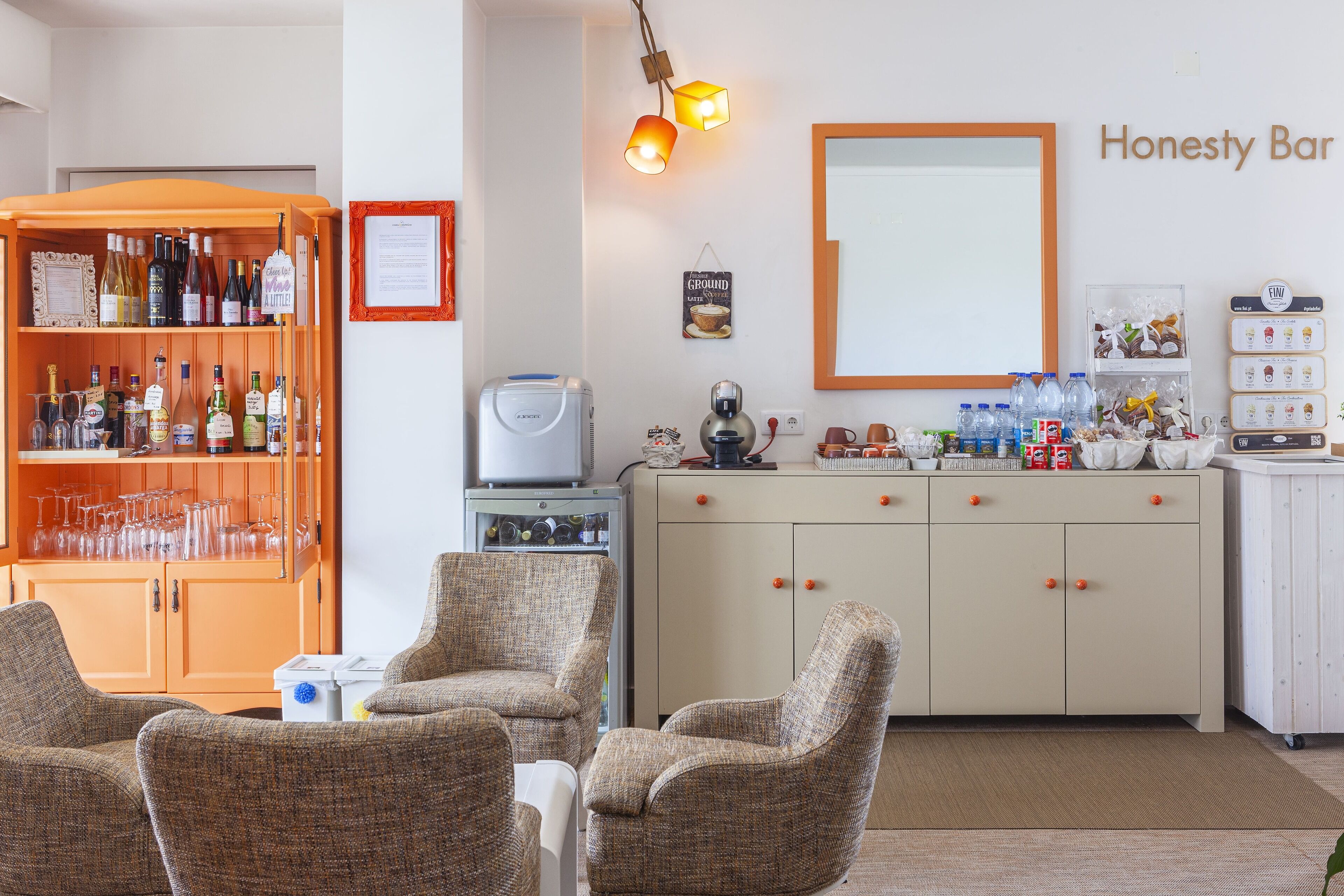 A bar area with a liquor cabinet, bar stools, and a mirror.