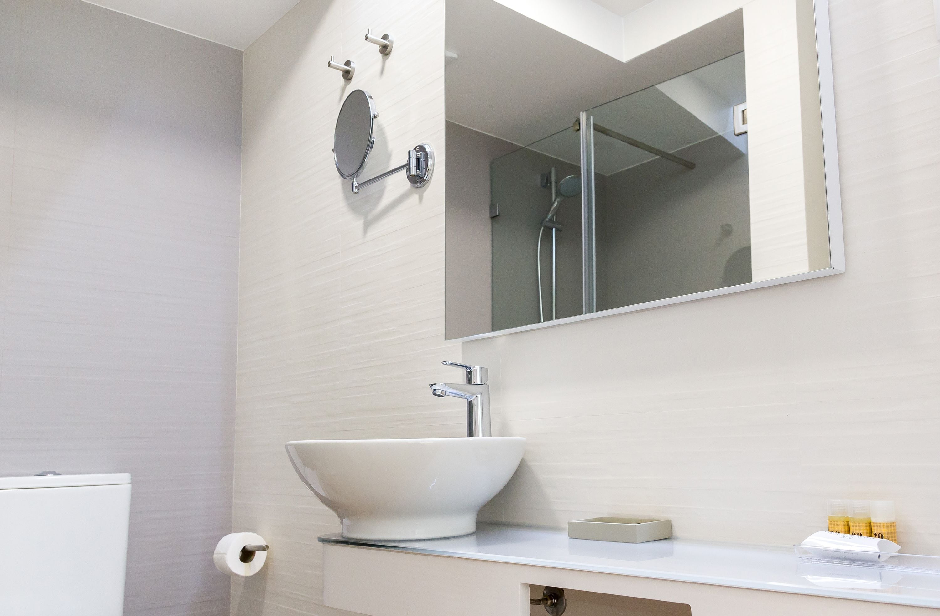 Un baño con un lavabo blanco, un espejo y un inodoro.
