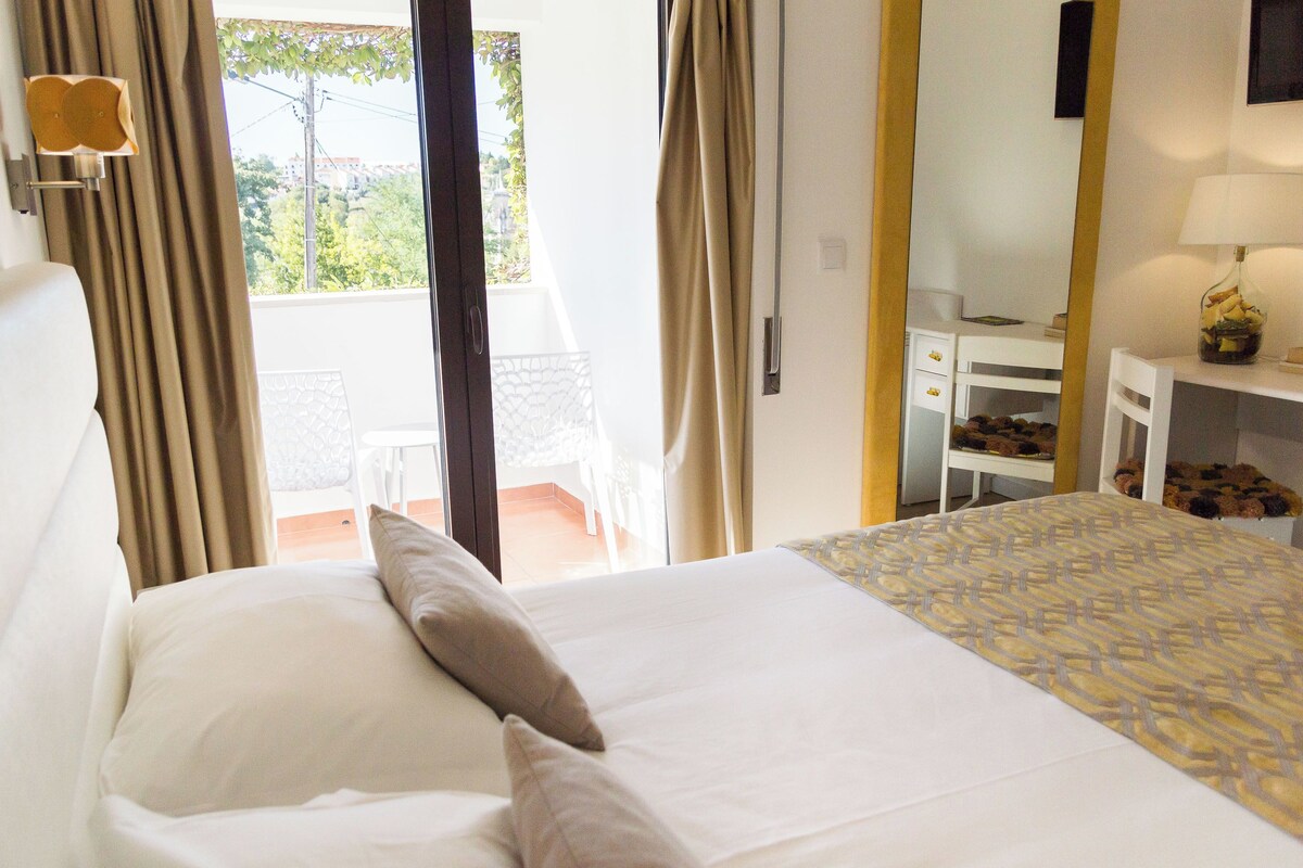 Une chambre d’hôtel avec un lit, un bureau et une vue sur l’extérieur.