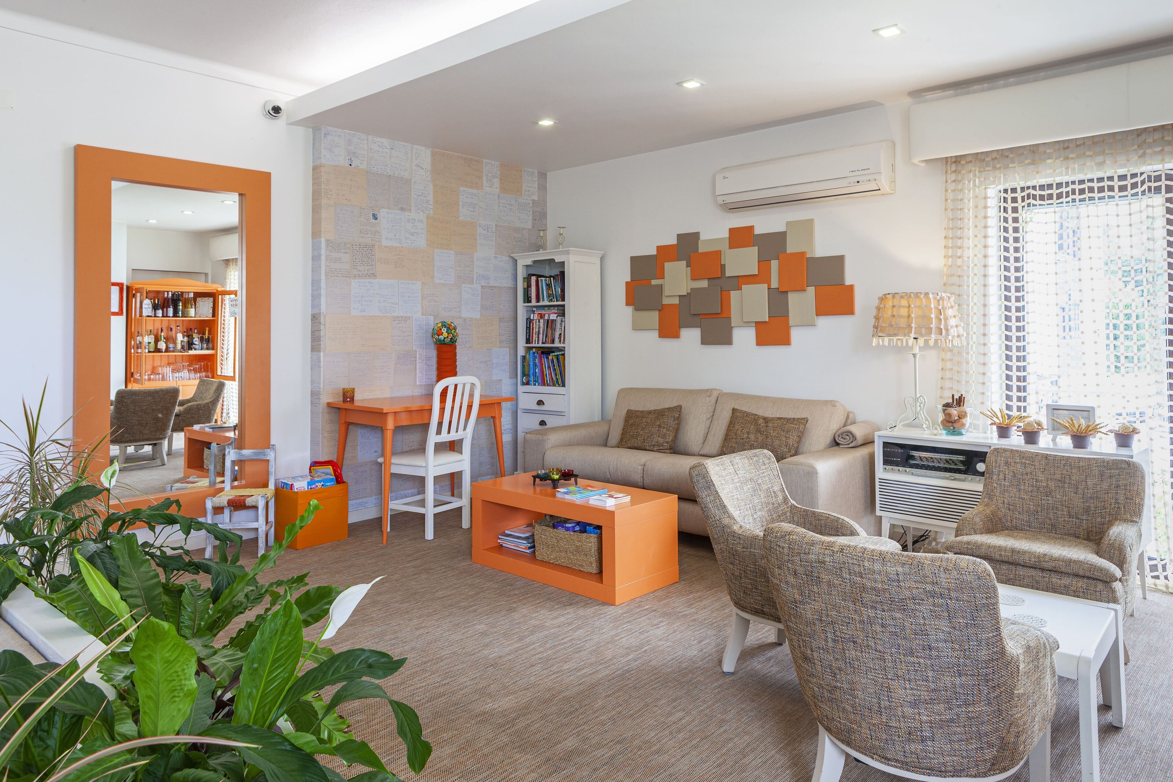 A modern living room with a sofa, armchairs, a coffee table, and a bookshelf.