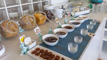 A buffet setup with various food items and serving utensils.
