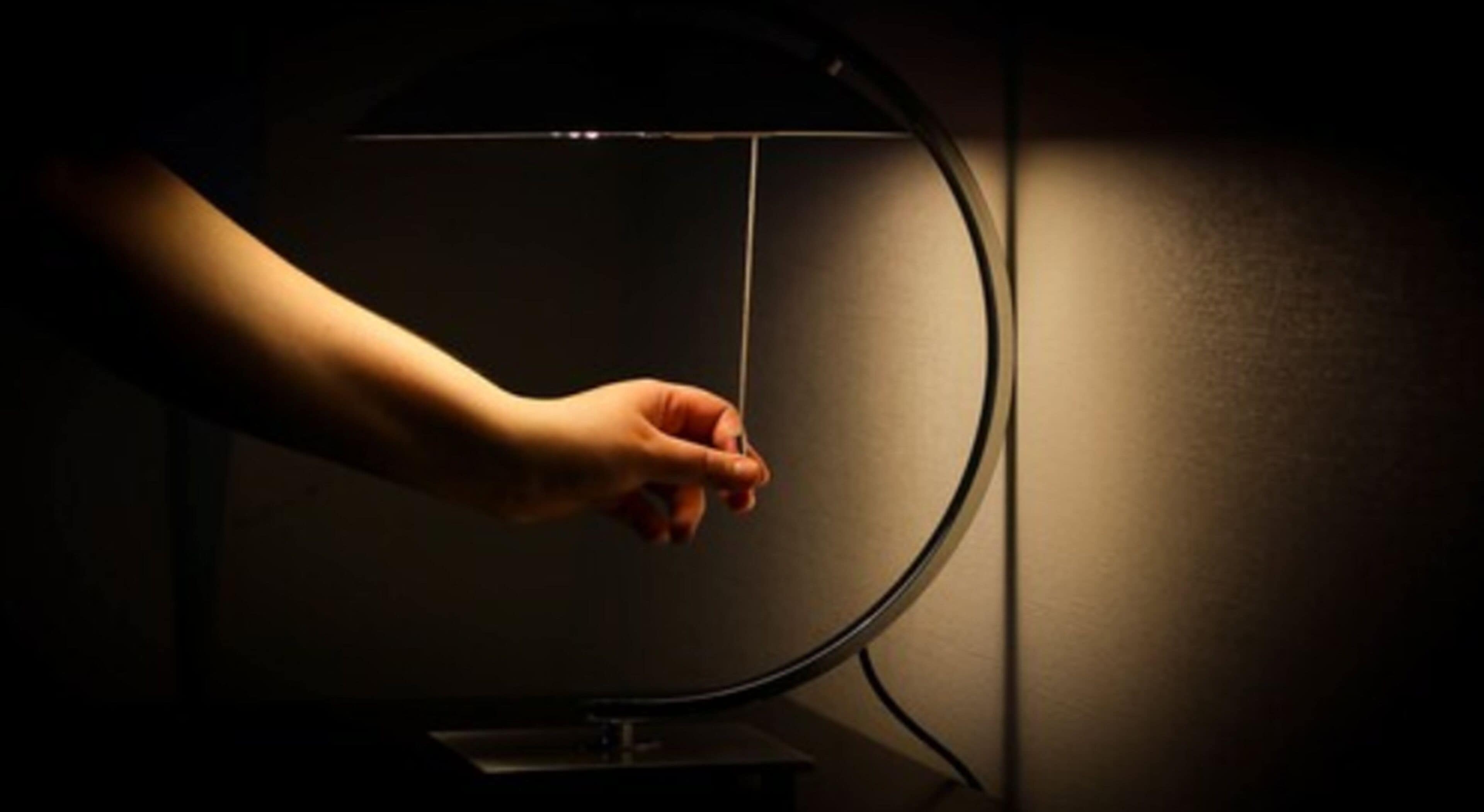A hand adjusting a light fixture.