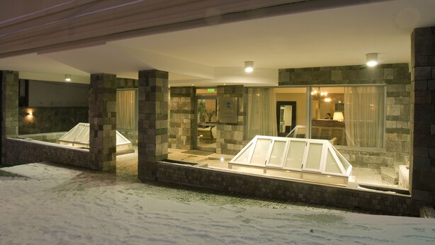 A hotel lobby with stone walls, a reception desk, and a glass display case.