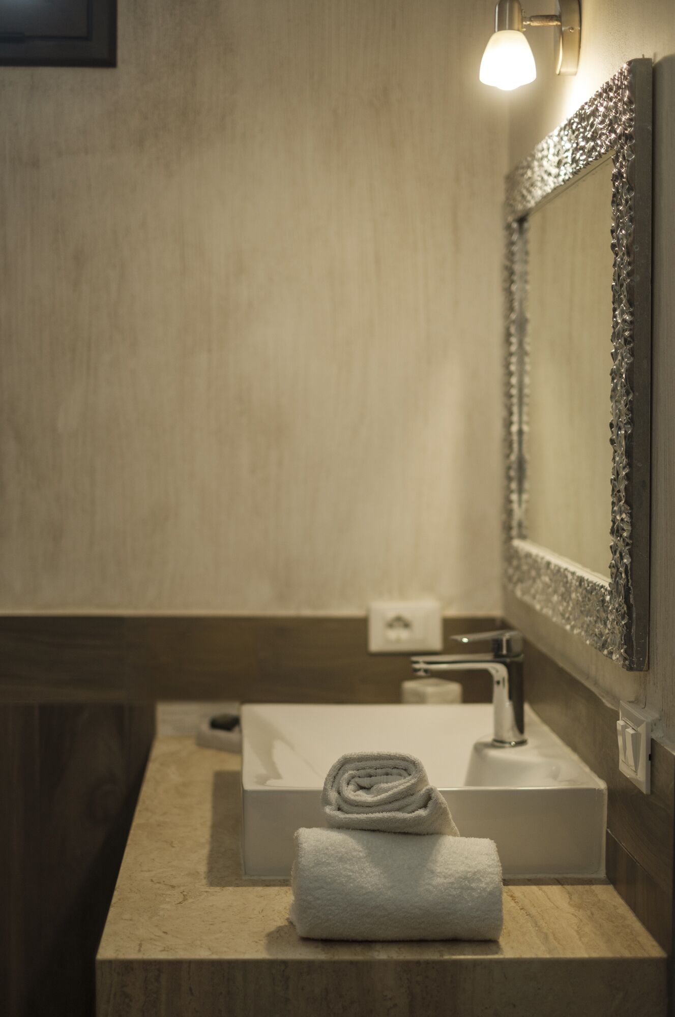 A bathroom with a sink, a mirror, and a towel.