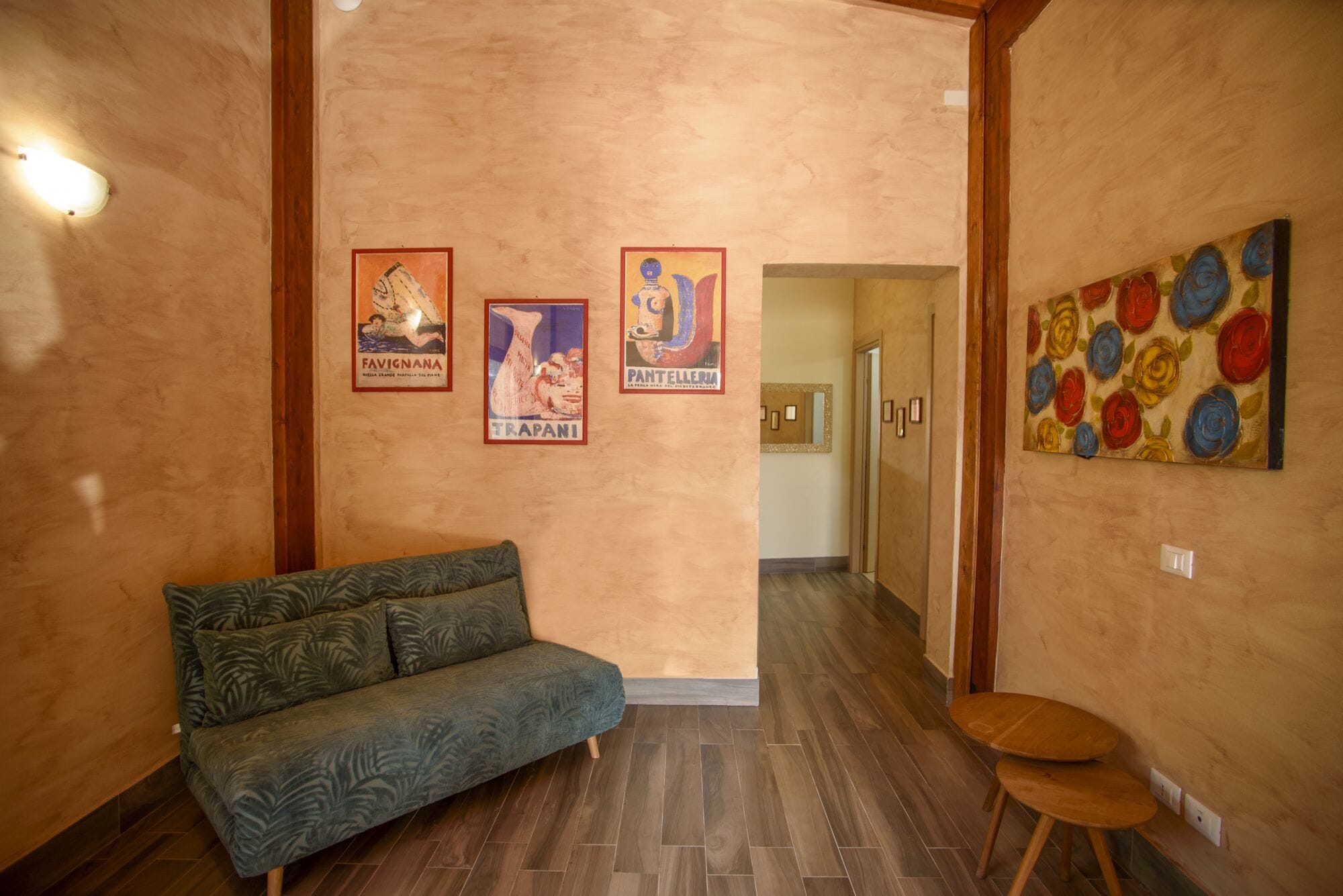Ein Flur mit einer Couch, einem Sessel und zwei gerahmten Postern an der Wand.