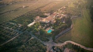 Vista aérea de una finca rural con piscina, caminos sinuosos y campos circundantes.