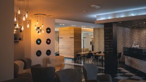 A modern interior with a checkered floor, a reception desk, and a wall with vinyl records.