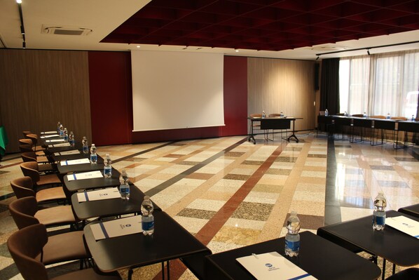 A conference room with rows of tables, chairs, and a large screen. - Best Western Mirage Hotel Fiera (Paderno Dugnano)