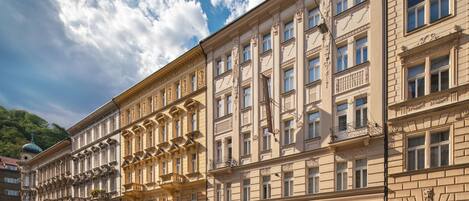 Un edificio de varios pisos con arquitectura clásica, que presenta balcones y ventanas amplias.