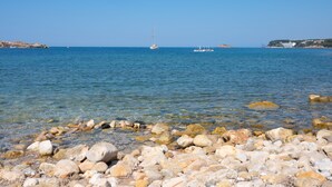 A rocky shoreline with clear water and boats in the distance. - Key Largo (Bandol)