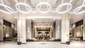 Un hall d’entrée spacieux, doté d’un éclairage moderne, de coins salon et d’un comptoir d’accueil.