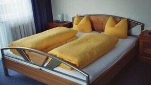 A double bed with a wooden frame and metal headboard, accompanied by two nightstands. - Alpenhof (Sankt Martin am Tennengebirge)