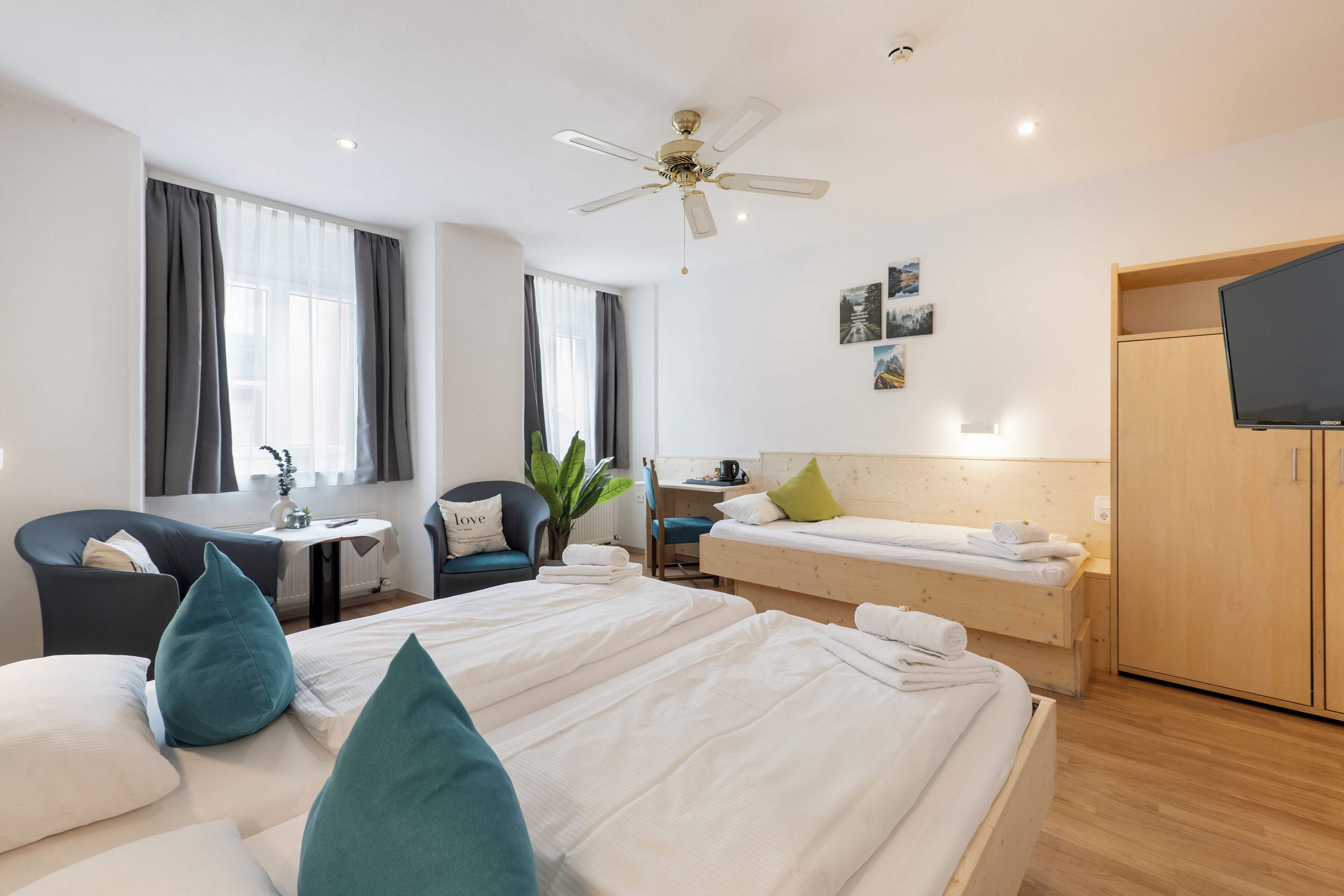 Une chambre d’hôtel comprenant un lit, un bureau, une chaise, une télévision et une armoire.