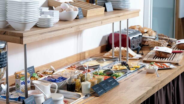 Een buffetopstelling met diverse soorten eten en bestek.