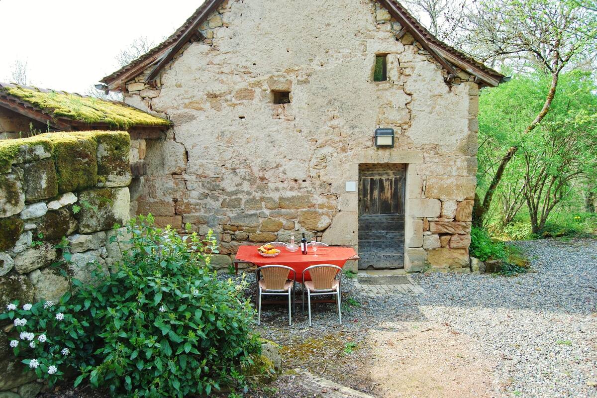 Un bâtiment rustique en pierre, doté d’une porte et d’une petite fenêtre.