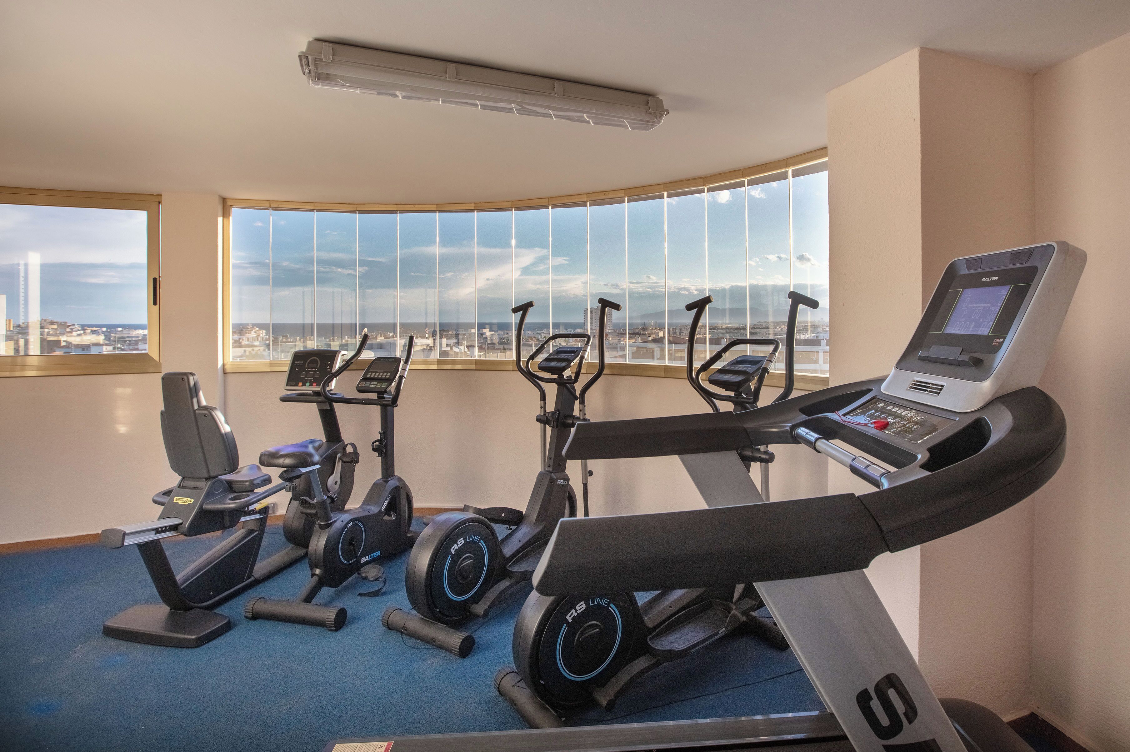 Ein Fitnessraum mit Ergometer, Laufband und Rudergerät.
