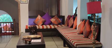 A room with a sofa set, a wooden coffee table, and a lamp.