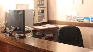 A reception desk with a computer monitor, a telephone, and a wall-mounted control panel. - Hôtel De Lorraine (Paris)