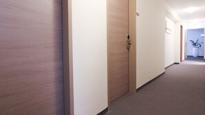 A hallway with wooden doors and a carpeted floor. - City Hotel Würzburg (Würzburg)