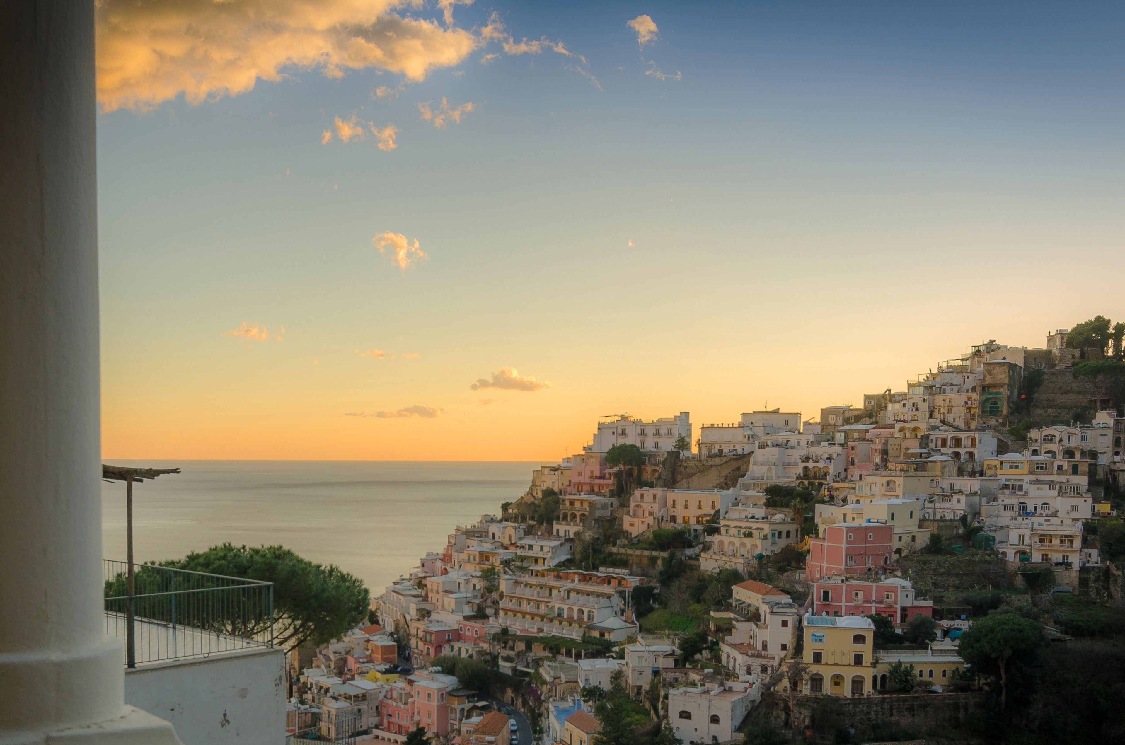 A coastal town with colorful buildings, a clear sky, and a view of the sea.