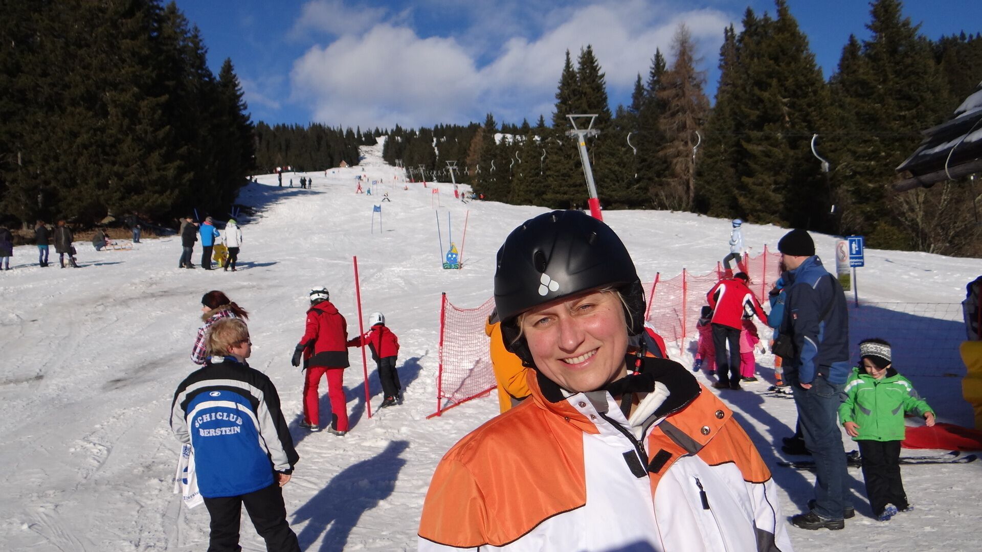 En skidbacke med skidåkare och snowboardåkare.