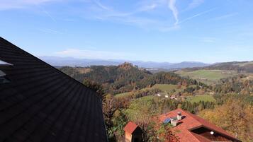 Aussicht auf eine Berglandschaft mit einem Haus im Vordergrund und einem klaren Himmel.