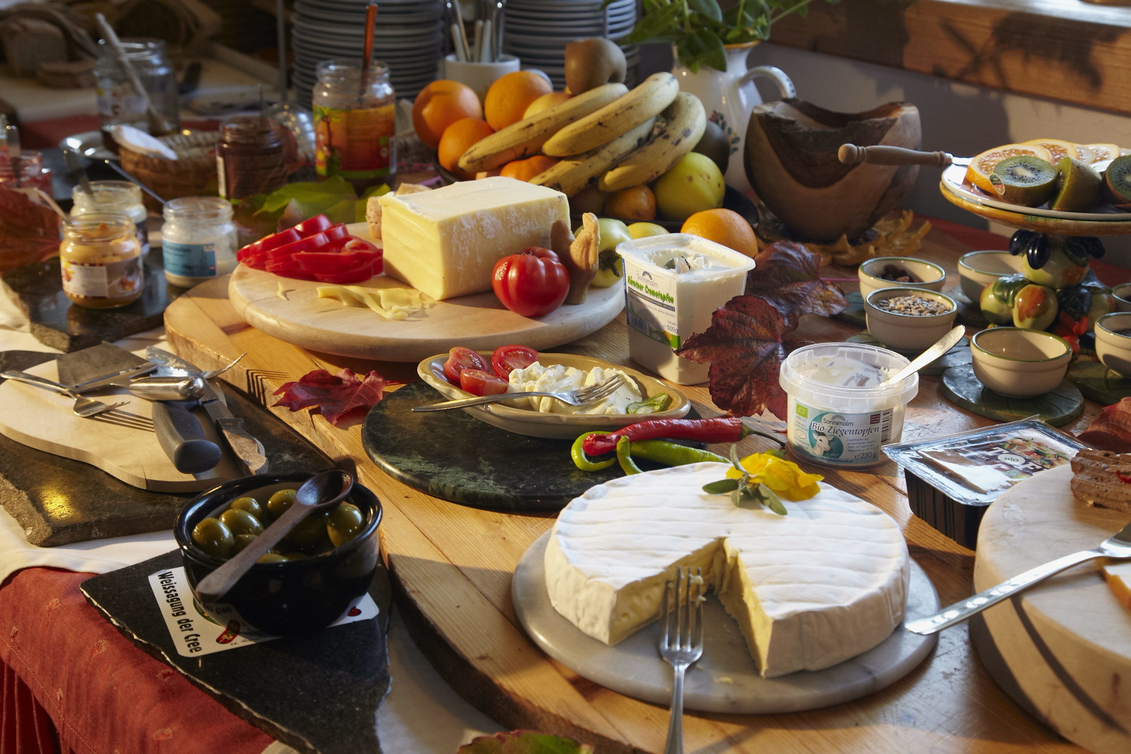 Ein reichhaltiges Buffet mit verschiedenen Käsesorten, Früchten und Beilagen.
