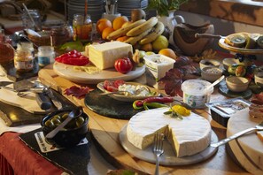 A buffet table with various cheeses, fruits, and condiments. - Biolandhaus Arche (Eberstein)
