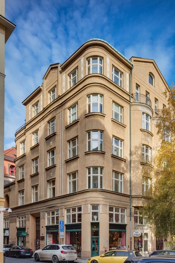 Un edificio de varios pisos con un estilo arquitectónico clásico, que cuenta con amplios ventanales y una entrada en esquina.