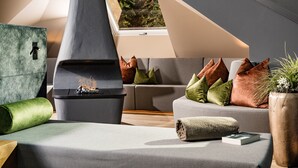 Un dormitorio estilo loft moderno con tragaluces, chimenea integrada y una zona de estar acogedora con cojines.