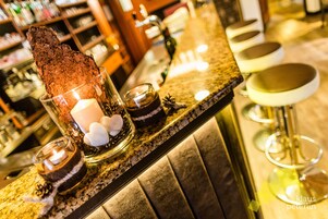 Zona de bar con un postre de chocolate, velas y taburetes.