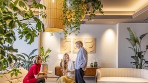 A modern living room with a round coffee table, sofas, and a hanging light fixture. - Tokyu Stay Yotsuya Shinjuku Area (Tokyo)